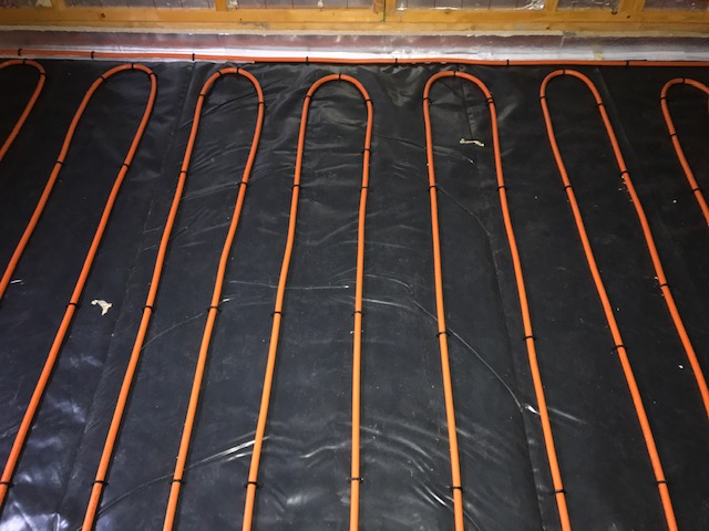 Solid floor underfloor heating system installed on insulation showing each loop in the underfloor heating pex pipe